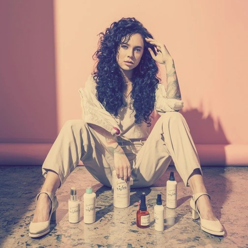 Woman sitting among haircare products