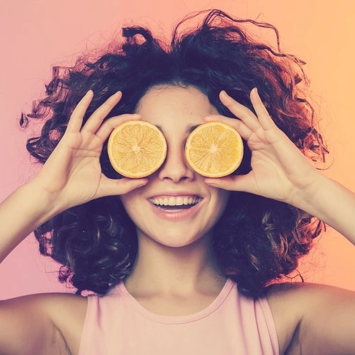 Woman playfully arranging orange slices